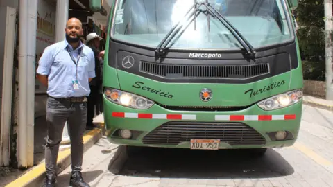 Wilson Chilo Cristian Alberto Caballero Chacón, head of operations for bus company Consettur, standing in front of one of its vehicles