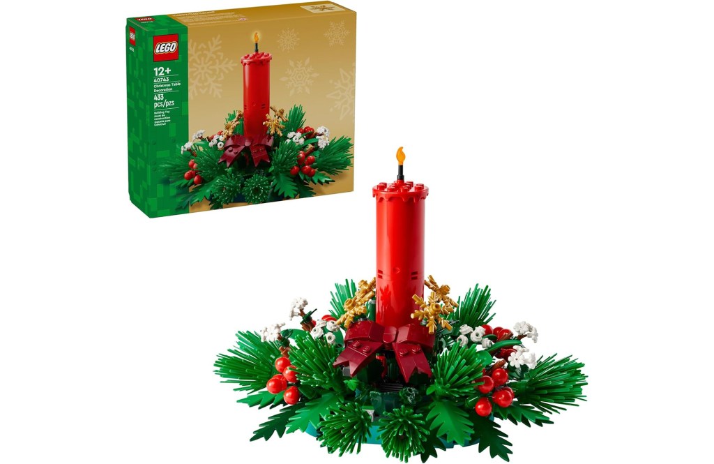A Christmas Table Decoration Lego set with 433 pieces shown with its packaging, featuring a red candle surrounded by green foliage, red berries, white flowers, and golden snowflakes.