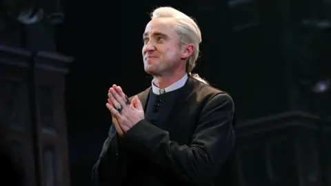 Getty Images Actor Tom Felton acknowledges the audience during the curtain call of his first performance in the "Harry Potter And The Cursed Child" show in New York on November 11, 2025