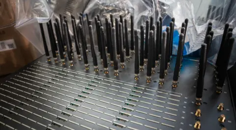 The Sim farm shown to our reporter includes lots of lines of slots for the cards themselves and then a variety of radio receivers sticking out at the top. There are as many as 64 slots for cards according to text on the device