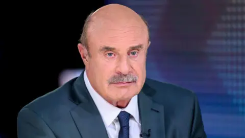 Getty Images A stock image of Dr Phil, who is wearing a navy suit and tie with a white shirt.
