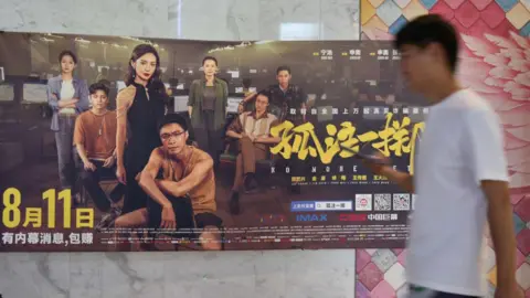 Getty Images A viewer walks by a poster of movie "No More Bets" 