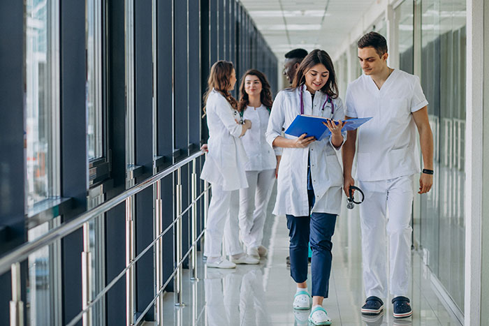 Group of medical professionals in white coats walking and discussing in a bright hospital corridor related to human body mysteries.