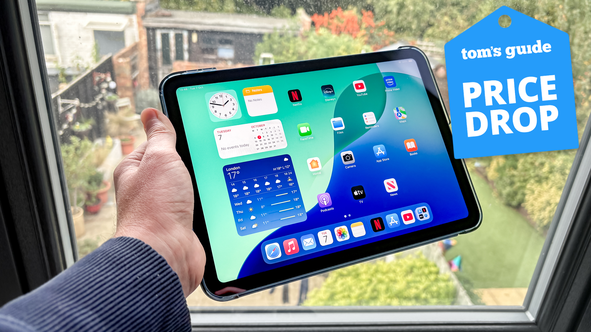 iPad 11 held in hand with Tom's Guide Price Drop badge