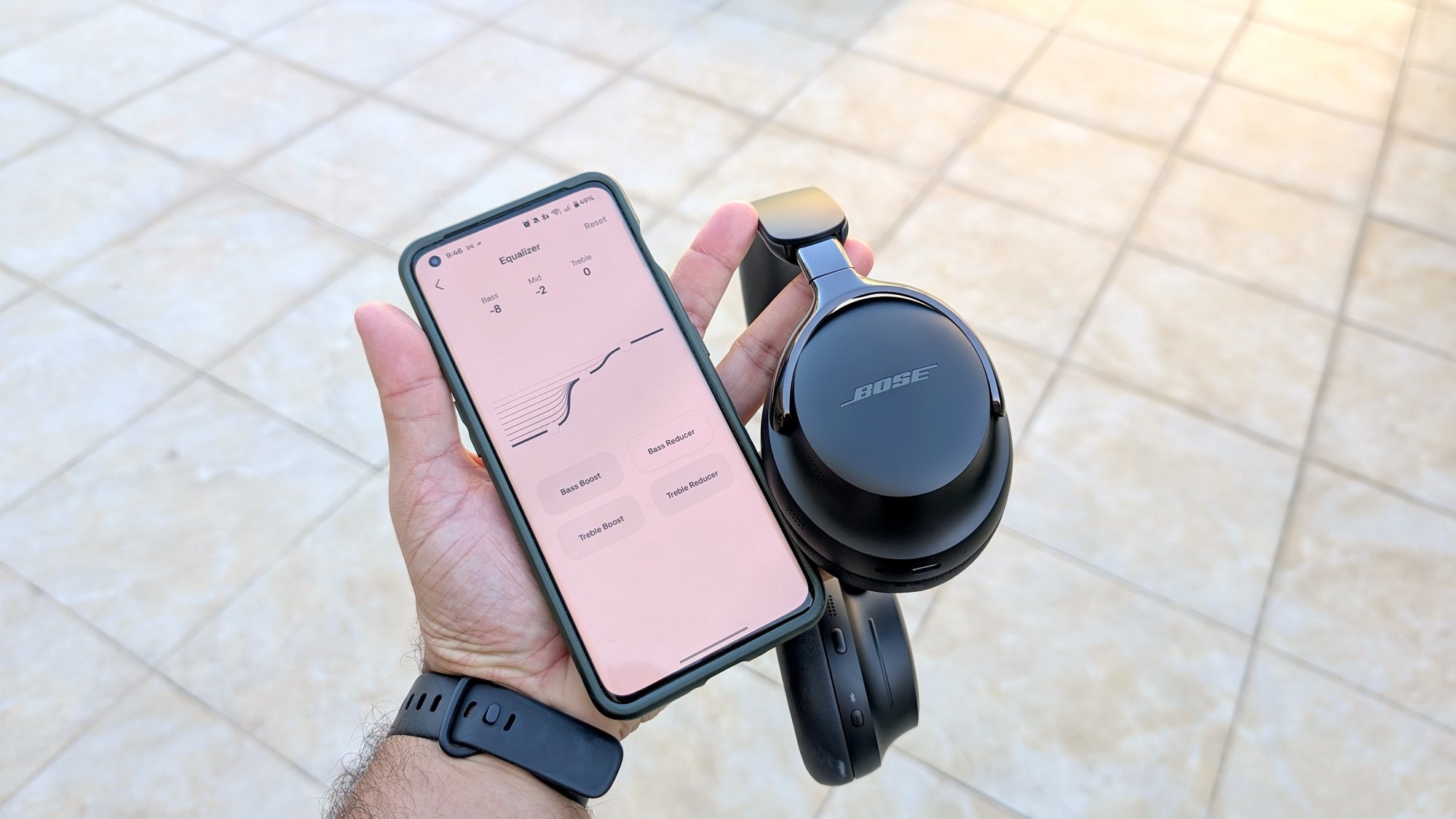 The Bose QC Ultra (Gen 2) headphones next to the Bose app, which is open to the equalizer settings