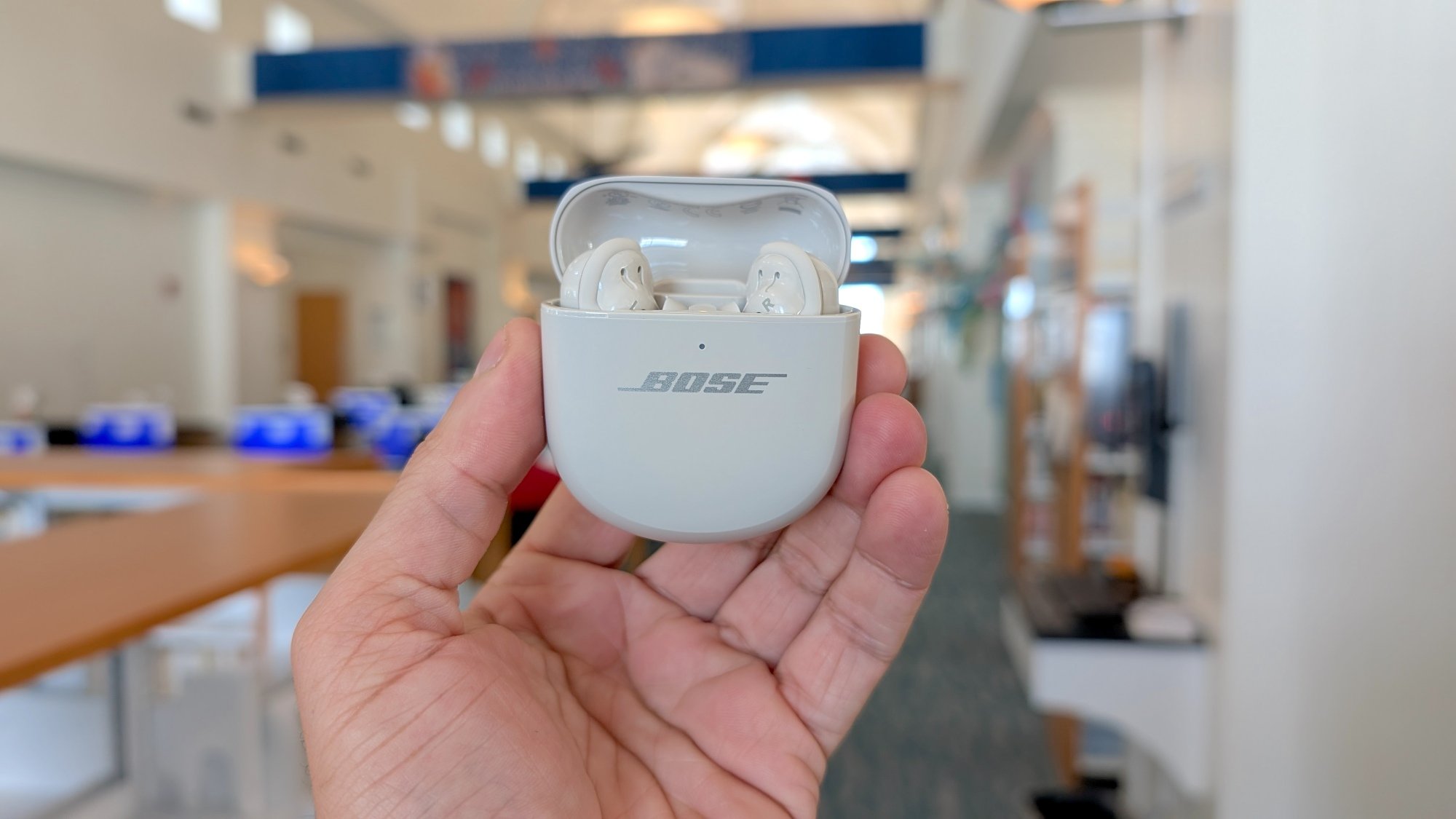 The writer holding up the Bose QC Ultra Earbuds (Gen 2) in their case.