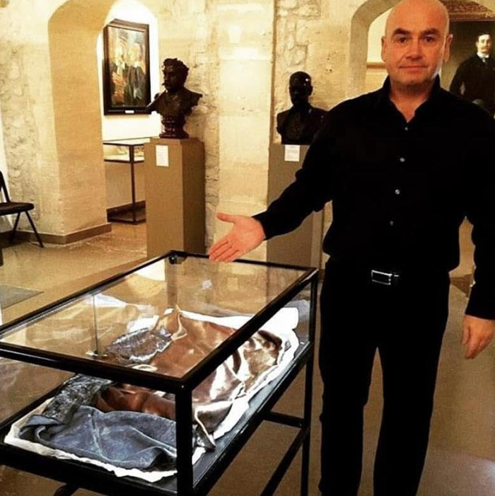Man in black shirt presenting an exhibit in a museum related to Jack The Ripper's real identity and DNA breakthrough.