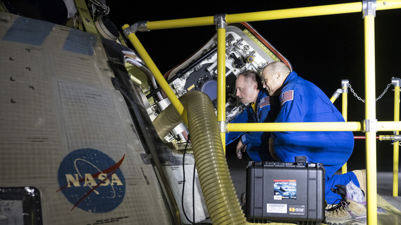 A ground team examines the Starliner capsule after its landing