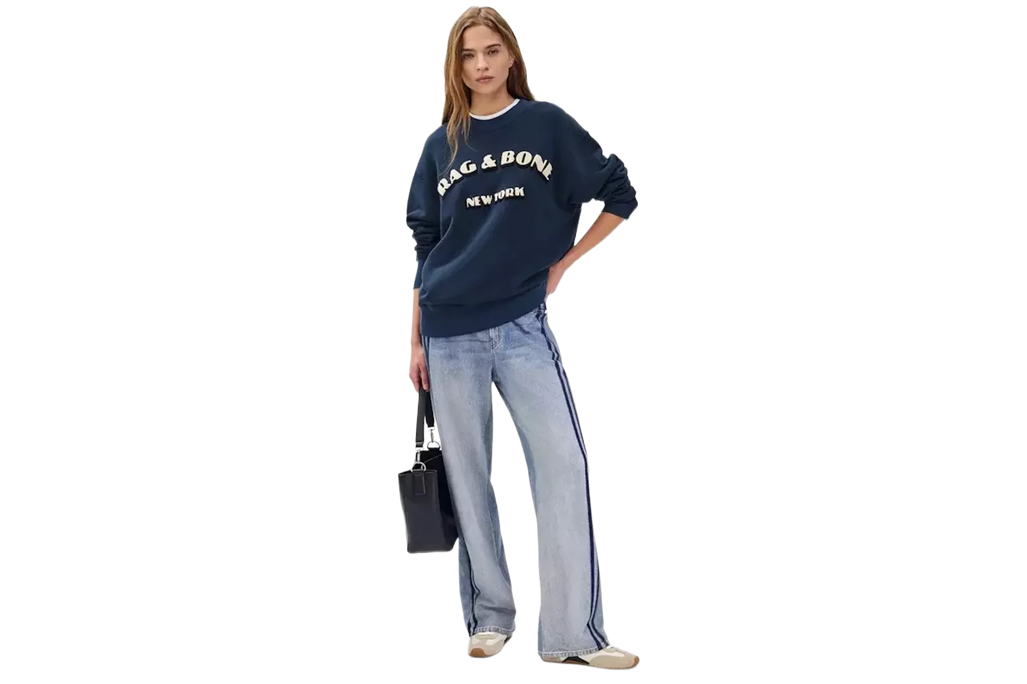 A woman in a navy sweatshirt with "RAG & BONE NEW YORK" across the chest, light wash jeans with a dark side stripe, and a black bag.