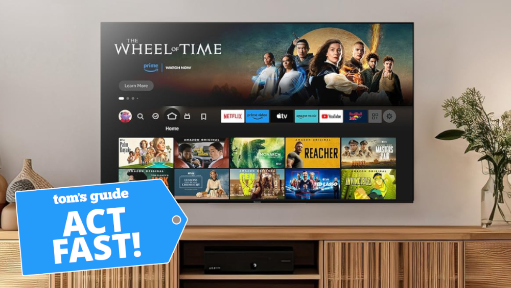 The Panasonic Z85A OLED TV mounted on a wall above a credenza. It is displaying the Amazon Fire TV home screen, which is showcasing an advertisement for the "Wheel of Time" TV series.