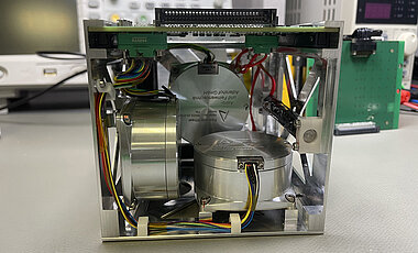 A metal box with multiple round cannisters inside sits on a white table