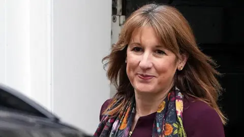 Getty Images Close-up of Chancellor Rachel Reeves wearing a floral scarf and burgundy top as she's about to get into a car