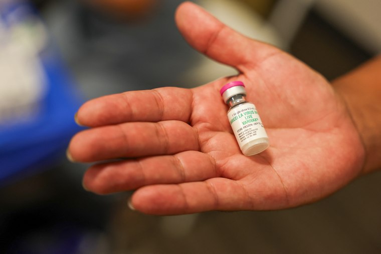 A person holds a vial for the Varivax vaccine