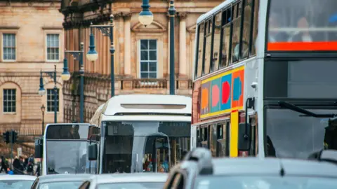 Getty Images A close up picture of a queue of cars and buses on a street in Edinburgh driving towards the camera. 