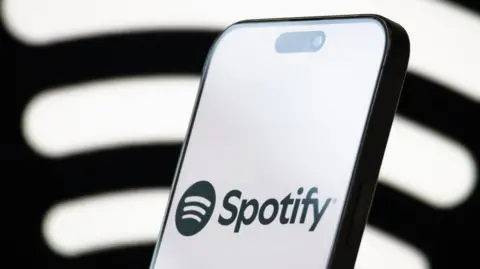 Getty Images A phone shows the Spotify logo