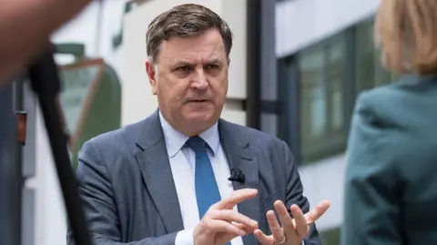 Getty Images Shadow chancellor Mel Stride doing an interview with a reporter. He is wearing a grey suit and blue tie.