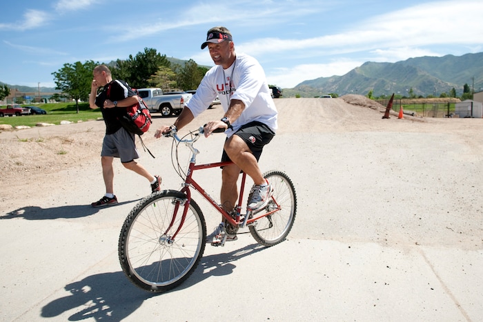 (Chris Detrick | The Salt Lake Tribune) Kyle Whittingham after rides his bike after a fall practice in 2011.