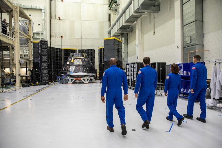 Four Artemis II crew members, shown inside the Neil Armstrong Operations and Checkout Building at NASA’s Kennedy Space Center in Florida, walk toward their Orion crew module.