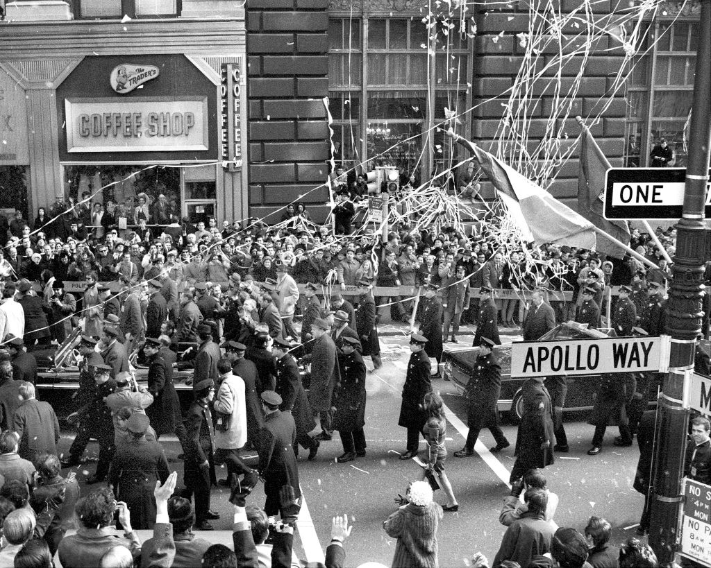 A black and white photo of a busy street with a street sign saying "Apollo Way"