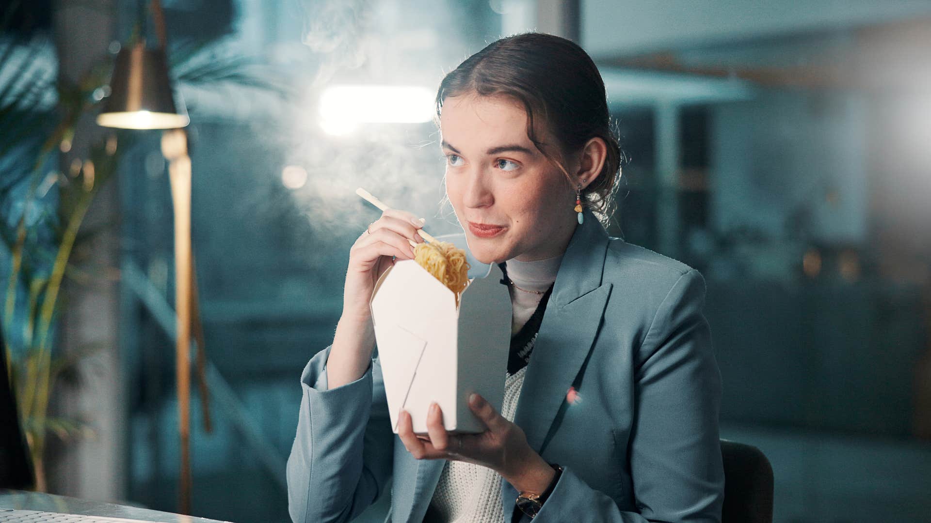 woman in suit eating takeout