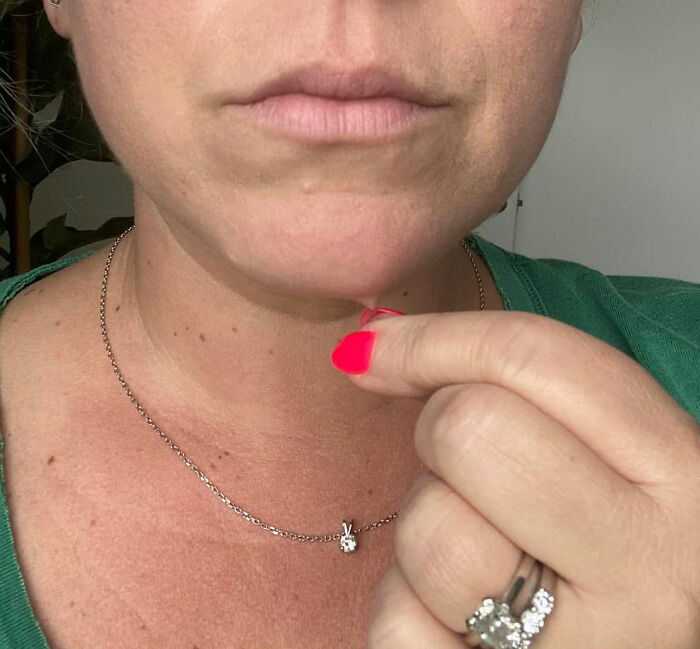 Close-up of a person with bright pink nails holding a small object near their chin, illustrating mysteries people want to solve.