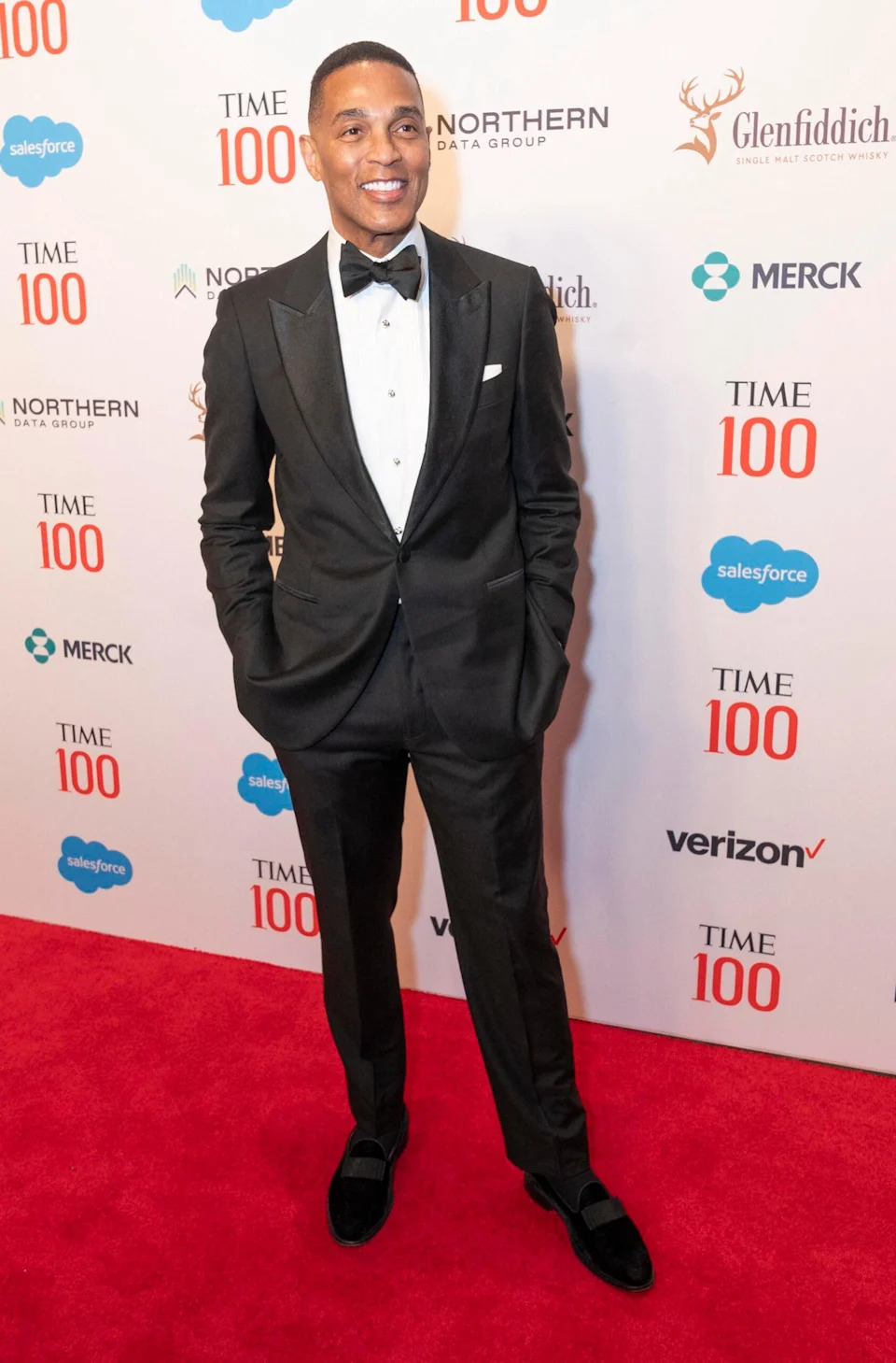 Don Lemon posing in a black suit on the red carpet.