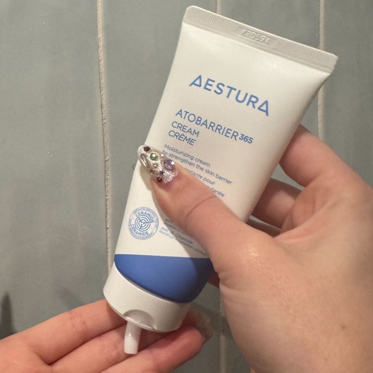 Woman dispensing cream on hand.