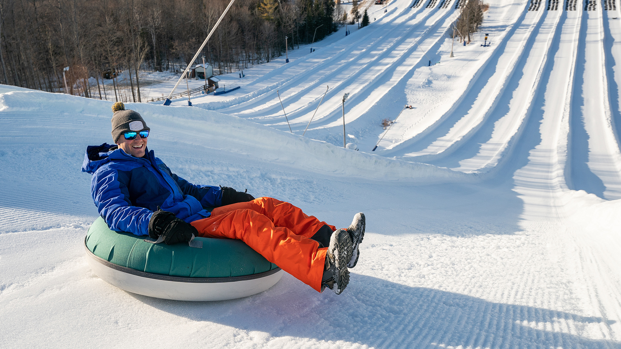 Man snow tubing in the winter in Canada; Shutterstock ID 1640769424; purchase_order: -; job: -; client: -; other: