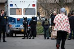 A U.S. Border Patrol police officer walks through the scene, filled with investigators and emergency personnel from other organizations including the FBI and HSI, at Adventist Health Building Three around the 10000 block of Main Street in Portland on Jan. 8, 2026, where two people were shot and wounded by U.S. Customs and Border Protection in East Portland earlier in the day.