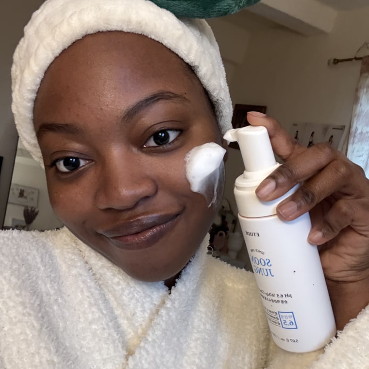 Woman applying foam cleanser on face