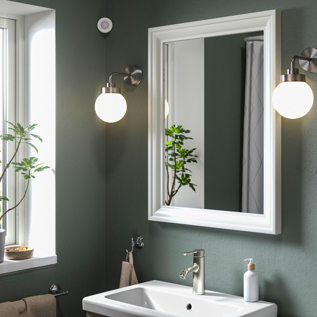 a bathroom with wall sconces lit up 