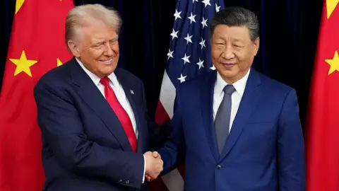 AFP via Getty Images US President Trump and Chinese President Xi shake hands in front of their country's flags