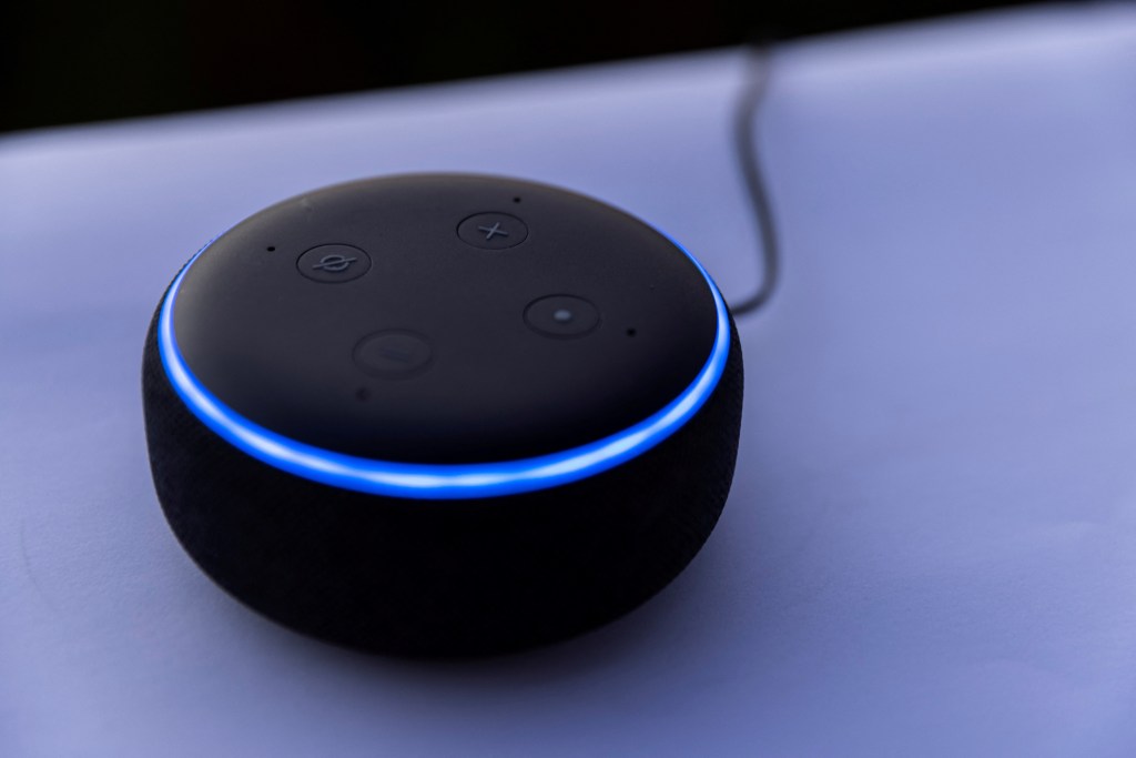 Amazon's Dot Alexa device, a round black device with a blue strip, in an illustration from October 1, 2021.