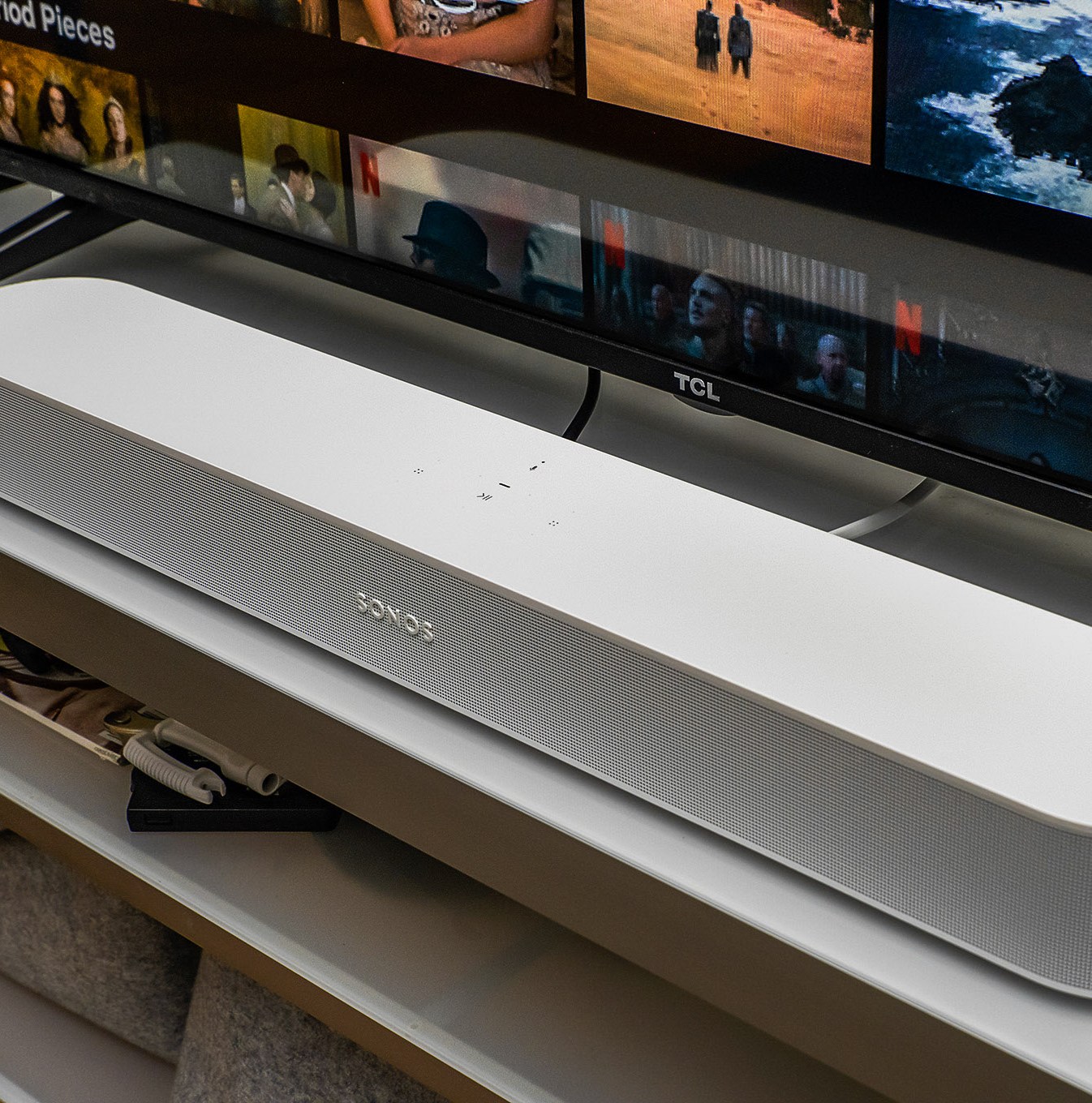 A photo of the white second-generation Sonos Beam soundbar in front of a TV