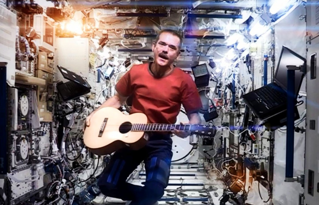 an astronaut with a guitar on the International Space Station