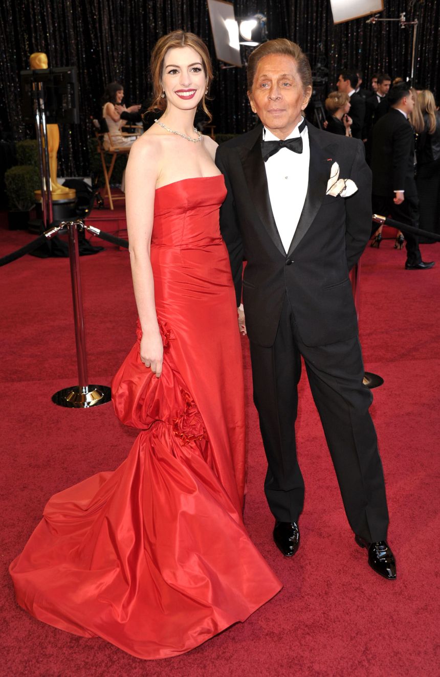 Anne Hathaway wore Valentino couture to the 2011 Academy Awards, arriving with the designer on the red carpet.