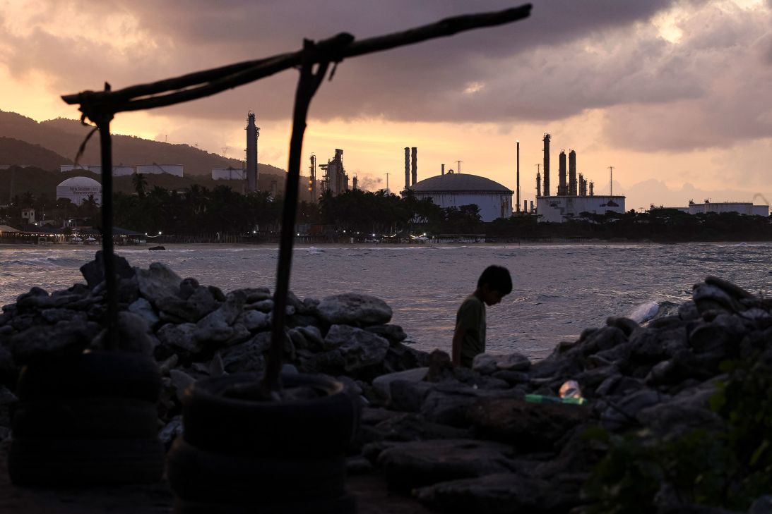 A child walks by a beach on the outskirts of 'El Palito' refinery on December 18, in Puerto Cabello, Venezuela.