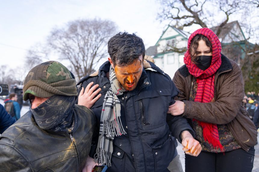 A bystander is helped by others after being hit with pepper spray shot by a US Border Patrol agent at the scene where a woman was shot and killed by a federal agent earlier, in Minneapolis, on January 7. 