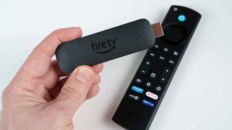 A person holding an Amazon Fire TV Stick.
