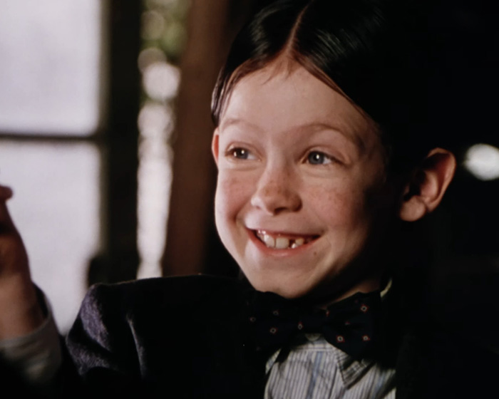 Young Little Rascals star smiling in formal attire, linked to living off the grid and Catholic extremist lifestyle.