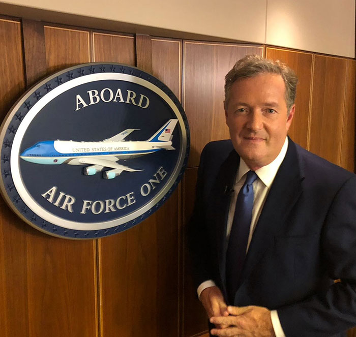 Piers Morgan standing beside Air Force One sign, relating to Donald Trump and serious injury incident.