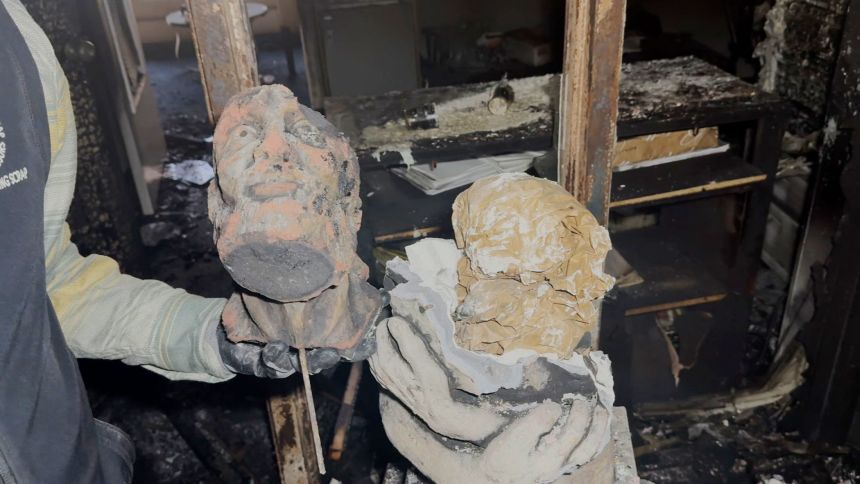 Shemper holds a piece of the Moses statue Tuesday after it broke following the alleged arson.