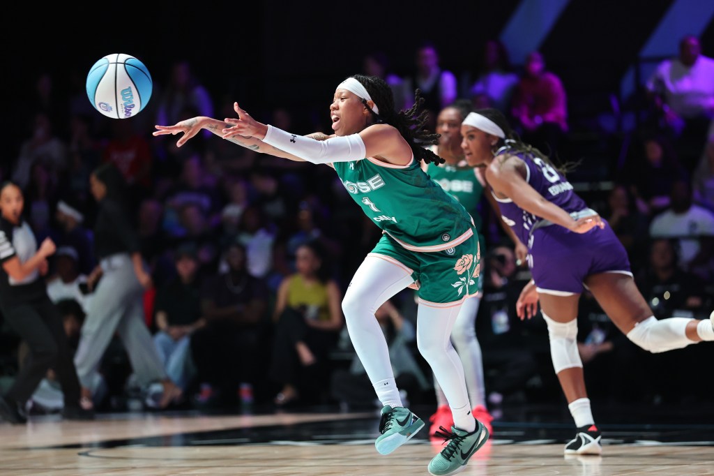 Sug Sutton passes the ball ahead of Aaliyah Edwards during the first half of a basketball game.
