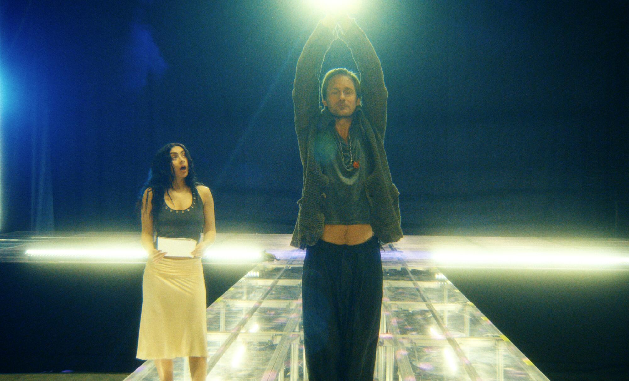 A woman and a man practice onstage.