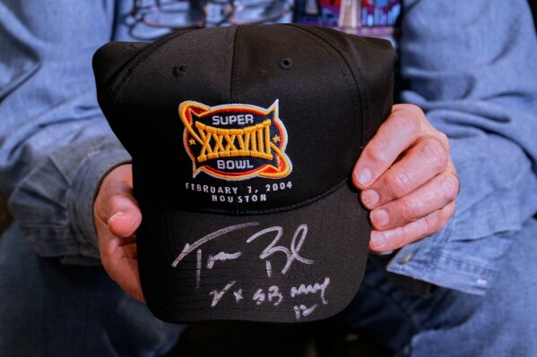 Don Crisman holds a Super Bowl 38 souvenir hat signed by Hall of Fame quarterback Tom Brady, Friday, Jan. 23, 2026, in Kennebunk, Maine. (AP Photo/Robert F. Bukaty)