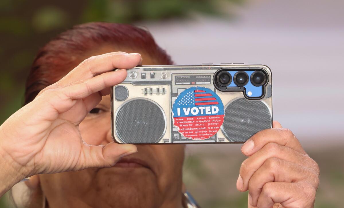 A woman takes a photo with her phone at the C. Erwin Piper Technical Center on Saturday.