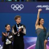 Gold medalists Laurence Fournier Beaudry and Guillaume Cizeron of France wave to the crowd in Milan as silver medalists Madison Chock and Evan Bates of the U.S. look on.