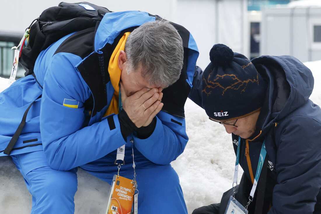 Mykhailo Heraskevych (L), the father of Ukraine's Vladyslav Heraskevych, reacts after his son was disqualified from the Milano Cortina 2026 Winter Olympic Games in Cortina d'Ampezzo on February 12, 2026. Ukrainian skeleton racer Vladyslav Heraskevych was disqualified from the Winter Olympics on February 12, 2026 after refusing to back down over his banned helmet, which depicts victims of his country's war with Russia. In a statement, the International Olympic Committee said Heraskevych is "not allowed to participate at Milano-Cortina 2026 after refusing to adhere to the IOC athlete expression guidelines".