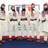 5 U.S. Olympians face the camera wearing red, white and blue sweaters and hats.