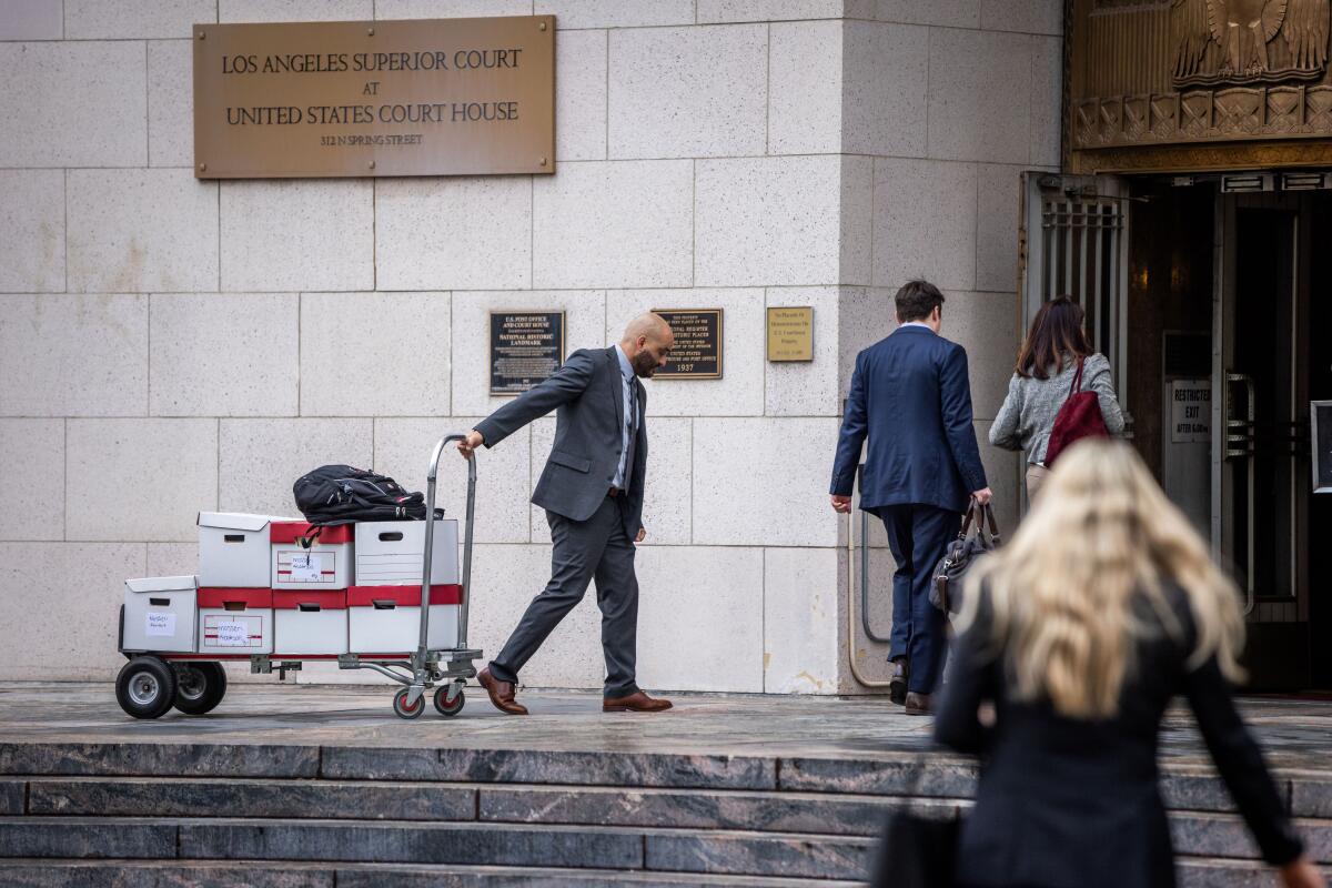 Boxes of documents are carried into the Los Angeles Superior Court